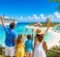 Familia saludando desde un mirador frente a una isla privada con toboganes y un crucero