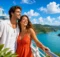 Pareja en la cubierta de un crucero pasando junto a cerros verdes y un gran puente