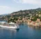 Crucero frente a un pueblo de casas de colores en la Riviera mediterránea