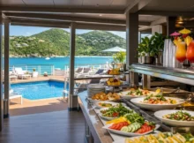 Bufé de frutas tropicales y jugos en la cubierta de un crucero frente a una playa del Caribe