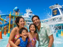 Familia con niños riendo en el parque acuático de la cubierta de un crucero