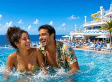 Pareja riendo dentro de la piscina de la cubierta de un crucero